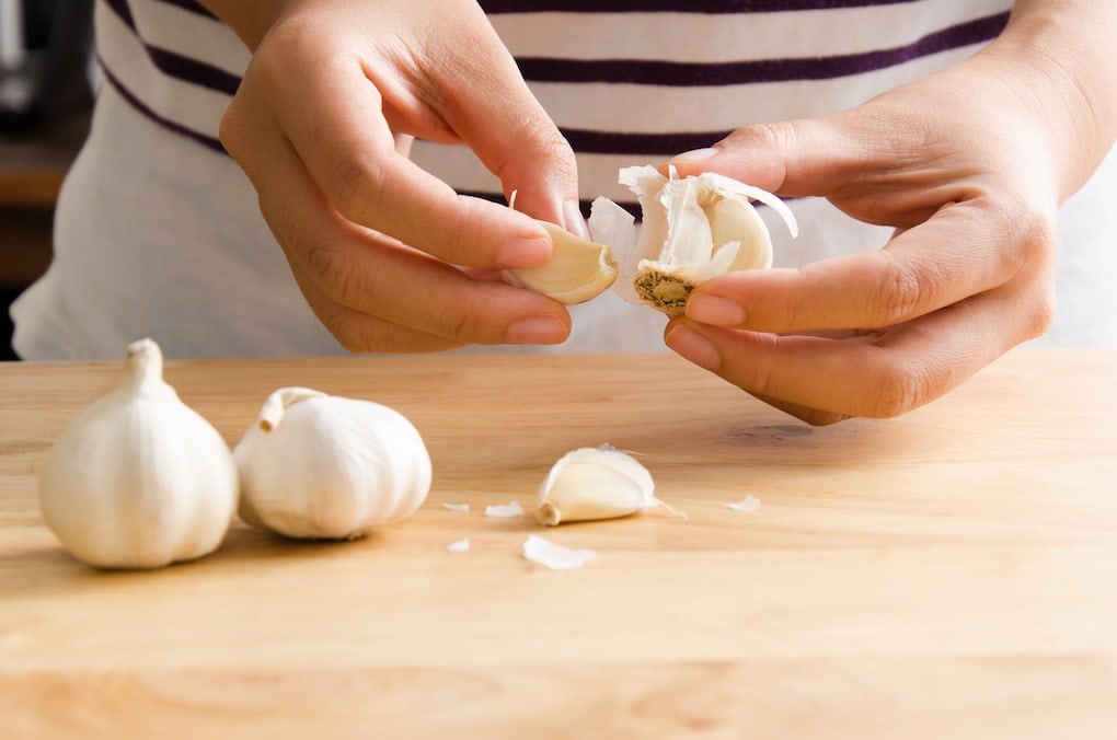 paio di mani che mostrano i migliori condimenti per diabetici;  aglio