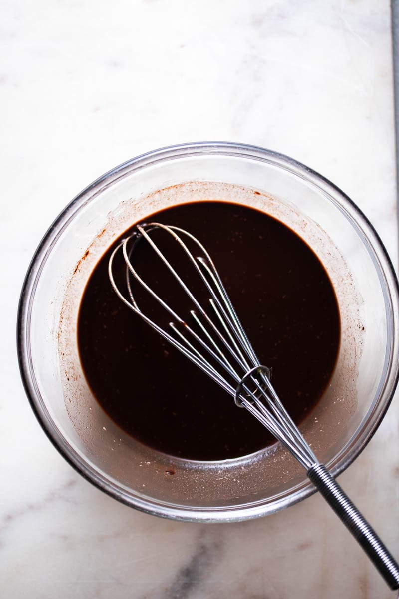 Ganache setosa al cioccolato in una ciotola con una frusta