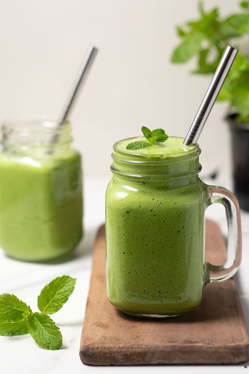 Frullato verde servito in bicchiere con cannuccia metallica